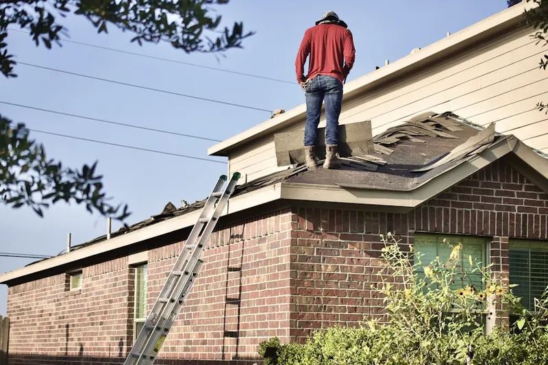Professional roofer working on a residential roof in Smith Village